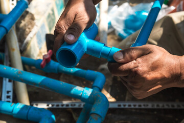 Close up plumber hands with water supply pipe installation