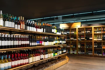 Foto auf Acrylglas Wine bottles in a row on shelves in wine store, alcohol retail business. © Barillo_Picture