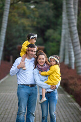 Fototapeta premium Family of four having fun outdoors in a beautiful sunny day at the park. Happiness concept. Family concept.