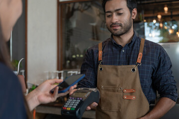 Woman use smartphone to scan QR code for order menu in cafe restaurant with a digital delivery....