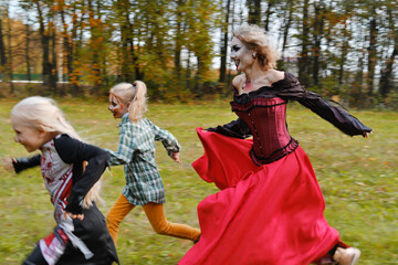 The family celebrates Halloween. Mom in the form of a vampire, girls in the form of a cheerleader...