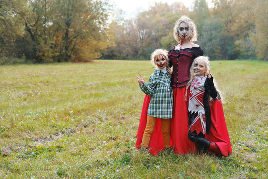 The Family Celebrates Halloween. Mom As A Vampire, Girls As A Cheerleader And A Pumpkin