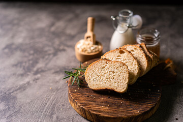 Artisan bread whole wheat baguette white milk and honey on rustic wooden board and abstract table. Sourdough bread
