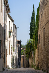 Fototapeta premium Vertical landscape view of old narrow street in the quaint historic city center of Montpellier, France in summer