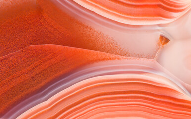 Amazing agate crystal cross section with mesmerizing layers of orange and violet wavy lines