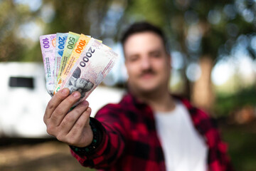 a handful of 100, 200, 500, 1000 and 2000 argentinean pesos banknotes.