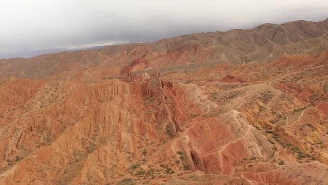 Scenic aerial view of famous Skazka Canyon in Kyrgyzstan during cloudy day. Famous destination in Issyk-Kul region. Mars planet red surface