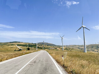 Fototapeta na wymiar country road with wind turbines on the sides