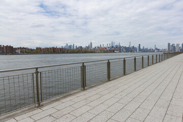 Empty Walkway along the East River at Domino Park with a View of the Manhattan Skyline in Williamsburg Brooklyn