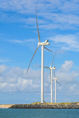Windrad steht an der Küste in den Dünen und erzeugt Energie durch Wind
