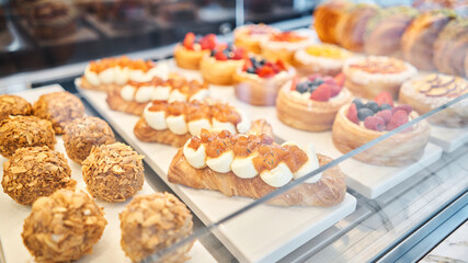 A variety of fresh pastries in the bakery window. almond croissant is fresh and hot in a cafe next to other types of pastries. fresh pastries with berries. The interior of an Italian restaurant.