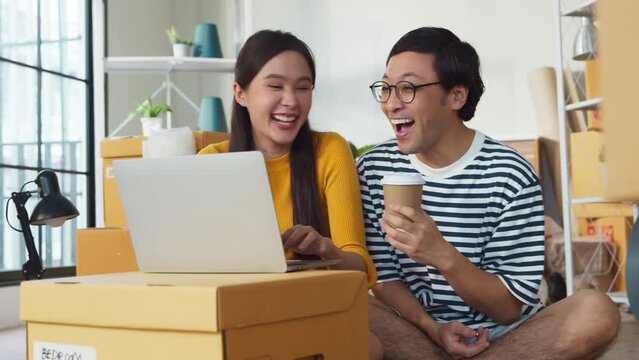 smiling enjoy home moving resting happiness asian marry couple sit on floor using laptop searching truck delivery for new home relocation home moving ideas concept,asian people packing boxes for move
