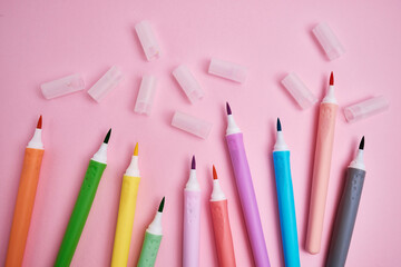 Many colorful markers on a colored background, flat lay. School stationery. The concept of study, office and drawing