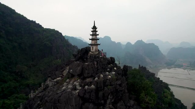 Vue a&eacute;rienne de Hang Mua &agrave; Ninh Binh au Vietnam, paysage karstique avec grotte, escalier et pagode sur la montagne du dragon couch&eacute;, culture et nature dans la baie d&rsquo;Halong terrestre.