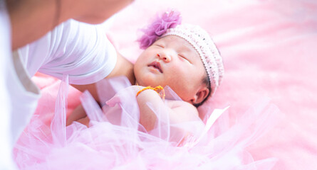 Mother holding baby,baby girl in pink skirt,Baby girl in a pink skirt. Selective focus. People,Baby girl newborn in pink tutu