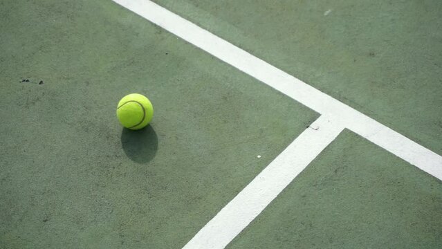 Tennis ball rolling to a stop on the court