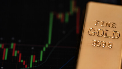 gold bars place on the phone that opens the candlestick chart. Fluctuations in gold prices concept.