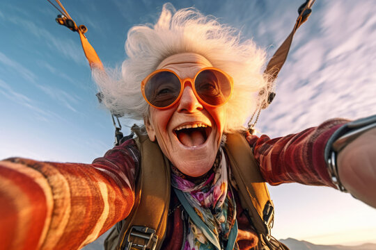 Grandmother taking a selfie while skydiving, doing parachute and flying in the sky. Active senior lifestyle concept : Sunset of life in colors.