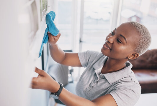 Cleaning, happy and dust with black woman in living rom for housekeeping, hygiene and disinfection. Janitor, hospitality and cloth with cleaner and washing in home for germ, bacteria and sanitary