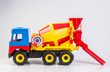 Multi-colored plastic toy trucks for children's games on a white background. Concrete mixer.