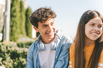 Fototapeta premium Stylish modern teenagers relaxing, summer vacation, talking with friends on street, outdoors