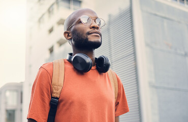 .Black man, student and walking outdoor on a city street while thinking of music and freedom. A...