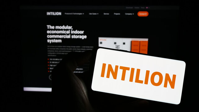 Stuttgart, Germany - 07-15-2023: Person holding cellphone with logo of German energy storange company INTILION AG on screen in front of business webpage. Focus on phone display.