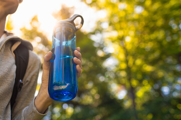 Active person outdoors holding bottle of drinking water 