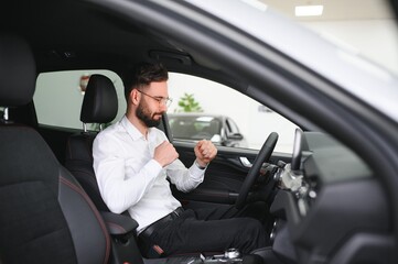 a man examines a car in a car dealership