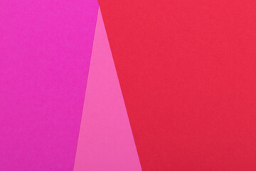 Multicolor background from a paper of different colors. Mix of pink, red and purple colors. Geometric backdrop.