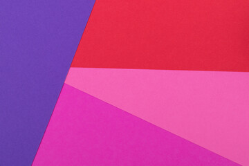 Multicolor background from a paper of different colors. Mix of pink, red and purple colors. Geometric backdrop.