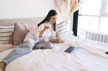 Smiling woman making distant video call chat on laptop