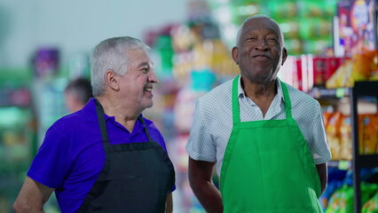 Diverse Elderly Workers Discussing Supermarket Business wearing aprons. An older caucasian manager...