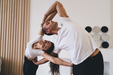 Happy diverse couple doing acro yoga in studio - Powered by Adobe