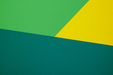 Multicolor background from a paper of different colors. Mix of yellow, green and dark green colors. Geometric backdrop.