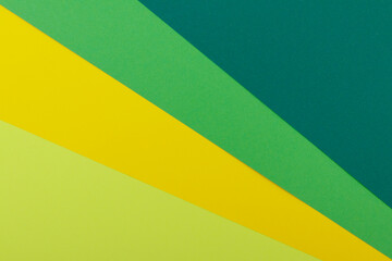 Multicolor background from a paper of different colors. Mix of yellow, green, dark green and lime colors. Geometric backdrop.