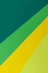 Multicolor background from a paper of different colors. Mix of yellow, green, dark green and lime colors. Geometric backdrop.