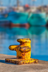 Vertical shot of a rustic yellow bitts single bollards at the Hout Bay harbour, Cape Town, South Africa