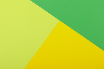 Multicolor background from a paper of different colors. Mix of yellow, green and lime colors. Geometric backdrop.