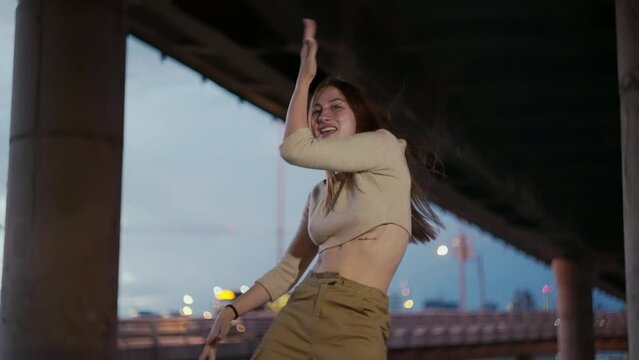 Sexy girl dances street dance in urban landscape. the movements of the city in the rhythm of music and dance and a beautiful woman. High quality 4k footage
