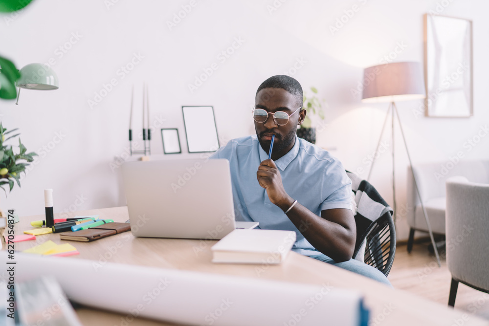 Poster black student sitting at table and working on netbook