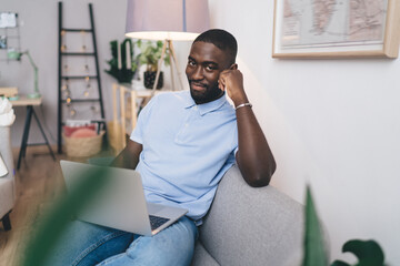 Fototapeta premium Happy black man working on netbook at home