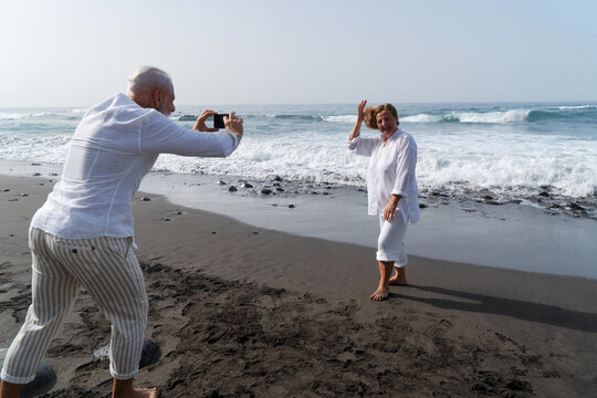 lifestyle of caucasian senior couple shooting photos on beach, happy in love romantic and relax time, tourism of elderly family pleople, leisure activity travel after retirement, vacations and summer