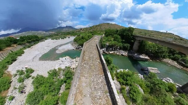 aerial view of Mesi Bridge, located in Albania, is an architectural gem that spans the Kir River in the picturesque village of Mesi. This historic stone bridge, dating back to the Ottoman period.