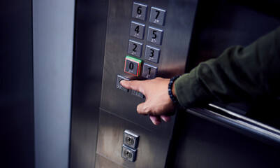 Man, hands and pressing button in elevator for transportation in building, floor or number indoors. Hand of male person selecting control on machine or lift for level up or down on touch panel