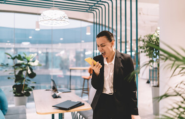 Angry businesswoman screaming into smartphone in office