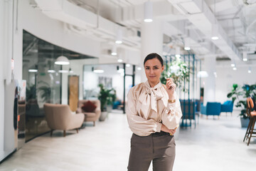 Smiling woman standing in spacious modern office hall