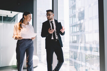 Confident colleagues walking in office hall