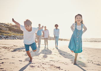Happy, excited and children playing on the beach on family vacation, holiday or adventure in...
