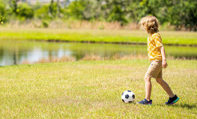 child enjoying childhood adventures outdoor. child playing football during childhood. Childhood memories of child boy. child while playing soccer football. Outdoor summer activity, copy space banner
